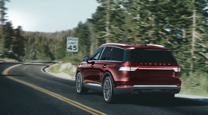 A 2024 Lincoln Aviator® SUV is being driven on a winding mountain road | Boulevard Lincoln in Georgetown DE