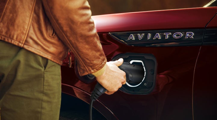 A hand is shown plugging in the charger into the charging port of a 2021 Lincoln Aviator | Boulevard Lincoln in Georgetown DE