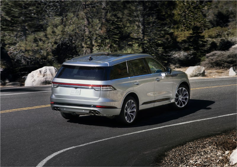 A 2023 Lincoln Aviator® Grand Touring model is shown being driven on a tight turn of a mountain road | Boulevard Lincoln in Millsboro DE