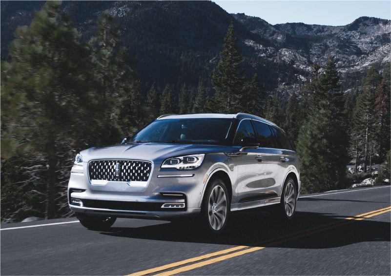 A 2023 Lincoln Aviator® Grand Touring SUV being driven on a winding road to demonstrate the capabilities of all-wheel drive | Boulevard Lincoln in Millsboro DE