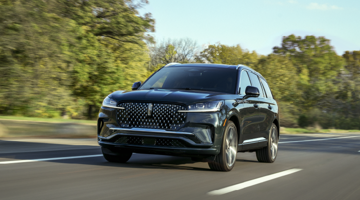A 2025 Lincoln Black Label Aviator® SUV is being driven down a road lined with trees. | Boulevard Lincoln in Millsboro DE