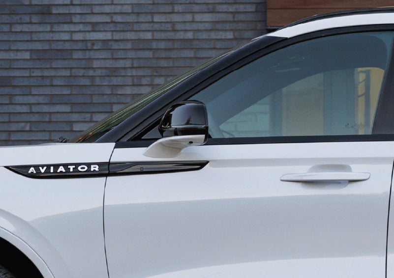 The driver’s side door and fender badging of a white 2026 Lincoln Aviator® SUV are showcased. | Boulevard Lincoln in Millsboro DE