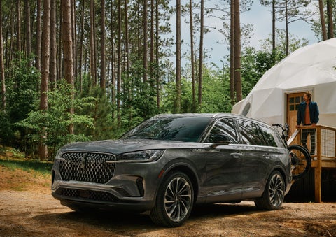 A 2027 Lincoln Aviator® is parked next to a high end glamping site. | Boulevard Lincoln in Millsboro DE