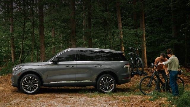 A father and son load e-bikes on a bike rack attached to a 2027 Lincoln Aviator® SUV. | Boulevard Lincoln in Millsboro DE